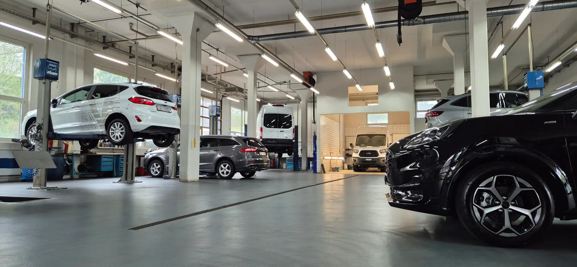 Werkstatt der Garage Voney AG mit Fahrzeugen auf den Hebebühnen