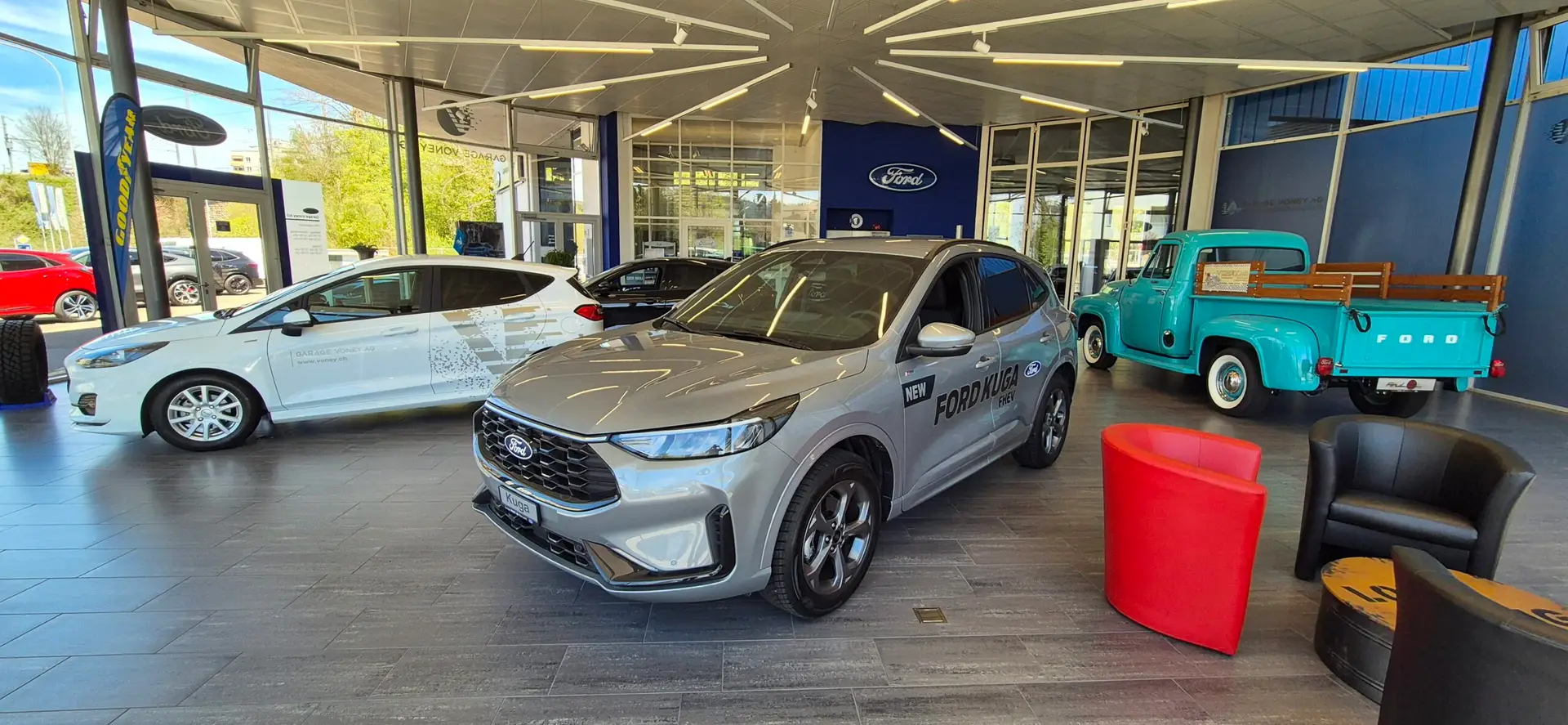 Ausstellungsraum mit Ford-Modellen und Lounge-Sesseln
